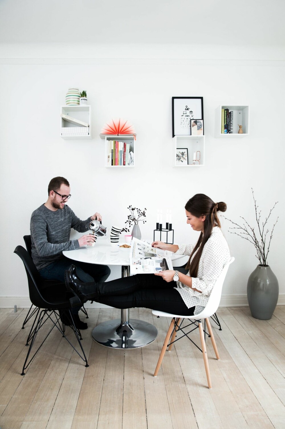 SMART LØSNING: Cecilie og Asger ved spisebordet fra Ikea. Stolene er fra biva.dk. Den hvite er fra Charles & Ray Eames, og er en klassiker de kan ha lenge. Enkle bokser på veggen gir et luftigere uttrykk enn skap eller reoler.