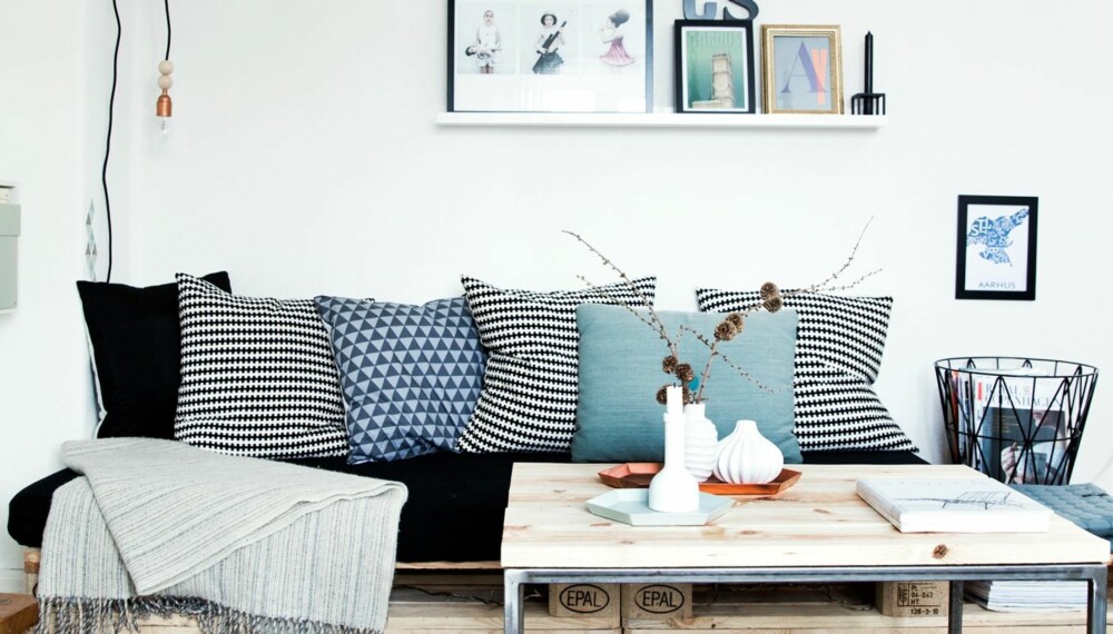 PALLESOFA: Hvitt, grått og støvet blått gjør stuen lys og trivelig. Pallesofaen med lyst tre understreker den skandinaviske stilen.