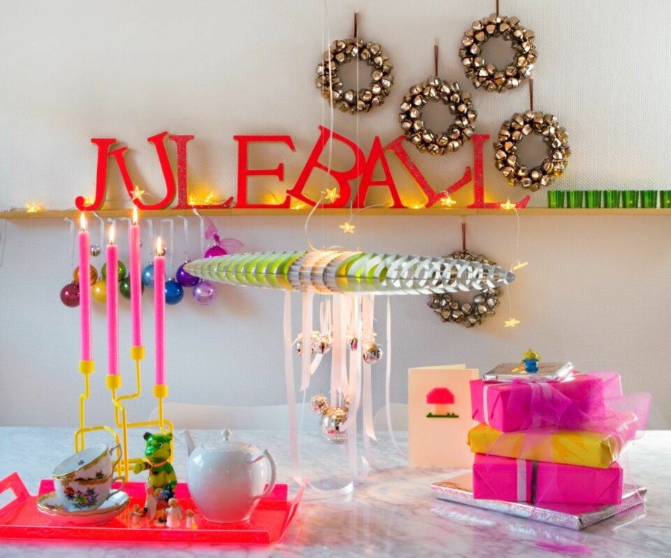 KNÆSJ JUL: Trebokstaver fra Fretex på veggen eller julekuler i knæsje farger er topp. Også kontraster, som neonbrettet fra Hole design med gamle, klassiske porselenskopper på, skaper en super effekt. Messingkransene med bjeller og den gule lysestaken er fra R.O.O.M., lampen i taket heter Titania og er fra Luce Plan.