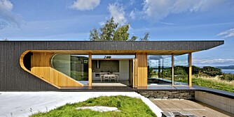 FULL FART OVER ARKITEKTUREN I ROGALAND: Arkitekt Tommie Wilhelmsen har tegnet  hytta på Rennesøy. De mørkbeisete veggene har oljet eik i de inntrukne partiene. Takutstikket skjermer og forhindrer at det blir for varmt inne i hytta sommerstid.