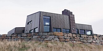 ET BORGAKTIG KYSTHUS : Se hvordan Frøya sommerhuset presser seg ned mot bakken med skrå vegger nesten hele veien rundt.