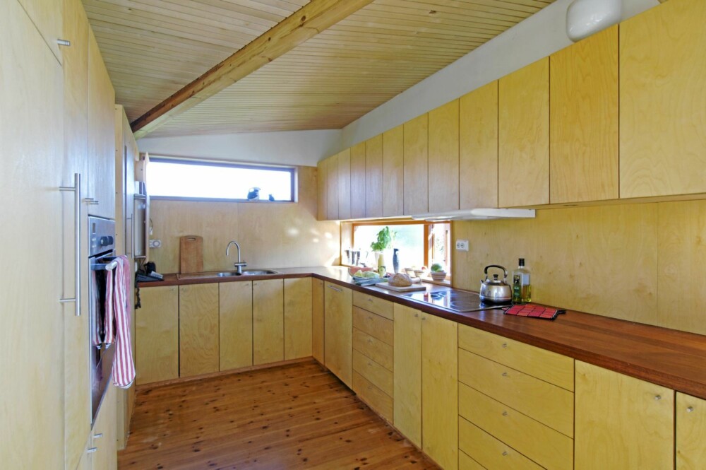 HELTRE TREND: Også det plassbygde kjøkkenet er laget i oljet bjørkefiner. Den mange meter lange kjøkkenbenken gir armslag for flere kokker på samme tid.