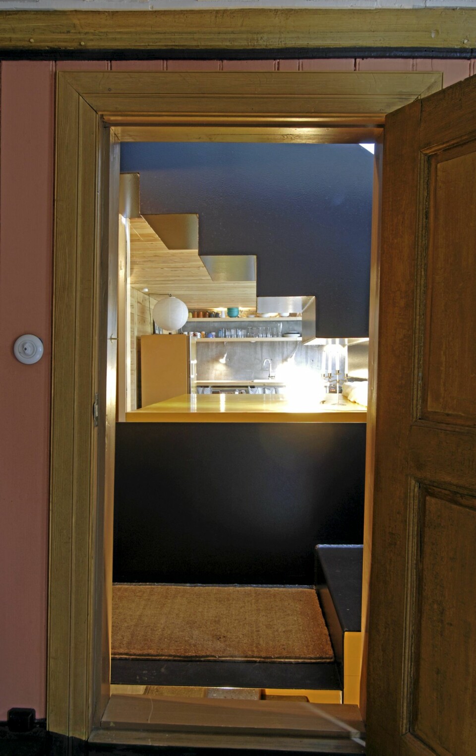 KULE KONTRASTER: Fra nabohuset datert 1850 ser vi et glimt av allrommet under den nye trappen. Knallgul soveplass.