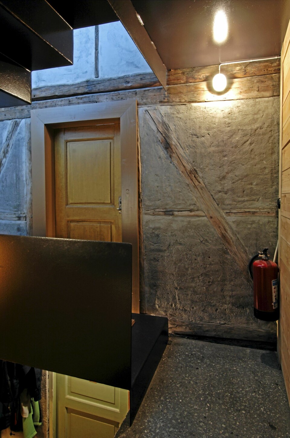 BINDINGSVERK MOT NY BETONG: Fra det nye trapperommet i tilbygget ser vi over til nabohuset som er reist i bindingsverk.