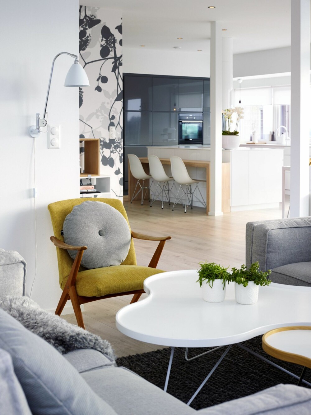 LANGE LINJER: Takhøyden i stuen er på 3,4 meter. Kjøkkenet er fra Kvik, med benkeplate i Corian bestilt på mål fra Tyskland. Lenestolen er et bruktfunn. Gulvteppet er fra Hay. For å skape dynamikk i det åpne rommet, valgte Janne å tapetsere en vegg med mønstret tapet fra Scandinavian Surface. LANGE LINJER: Takhøyden i stuen er på 3,4 meter. Kjøkkenet er fra Kvik, med benkeplate i Corian bestilt på mål fra Tyskland. Lenestolen er et bruktfunn. Gulvteppet er fra Hay. For å skape dynamikk i det åpne rommet, valgte Janne å tapetsere en vegg med mønstret tapet fra Scandinavian Surface.
