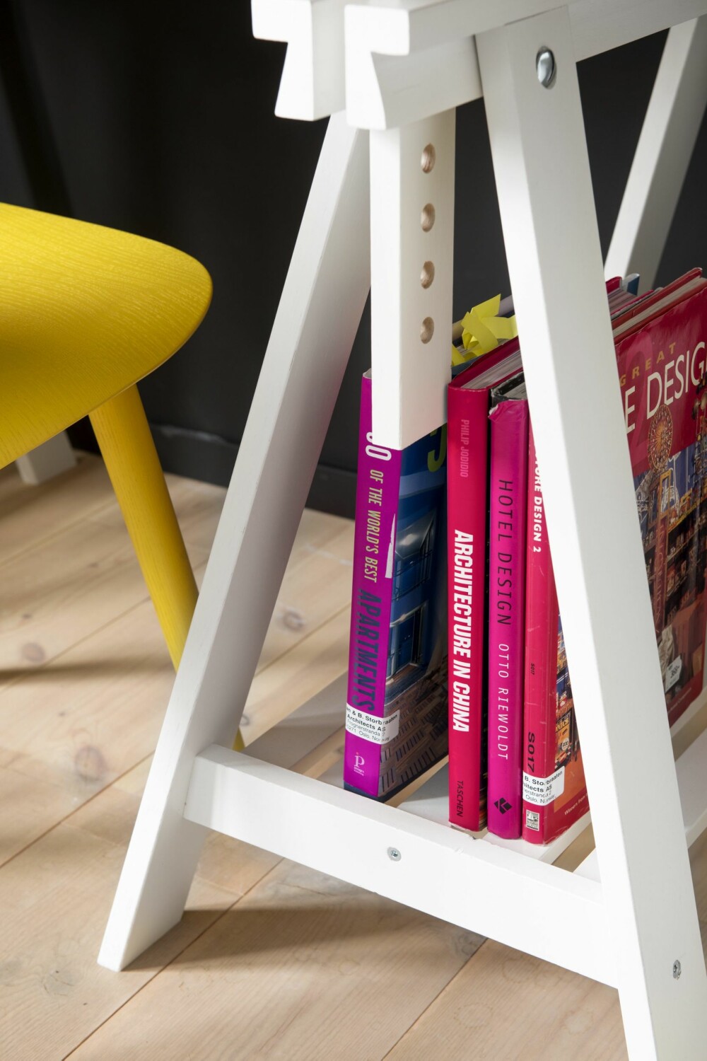 Fremhev farger. Skrivebordet fra Ikea er 120 x 60 cm. Bukkene under bordplaten brukes også til enkel oppbevaring. Det er valgt enkle møbler som ikke tar stor plass. Gul stol, Nerd Chair fra Muuto.