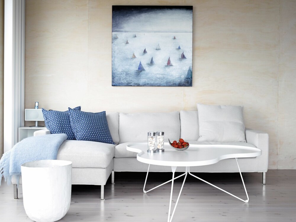 SMART TRIKS: Panelveggene i bjørkefiner gir en varm glød til rommet når de bades i naturlig sollys. Sofa fra Eilersen og bordet Flower fra Swedese.