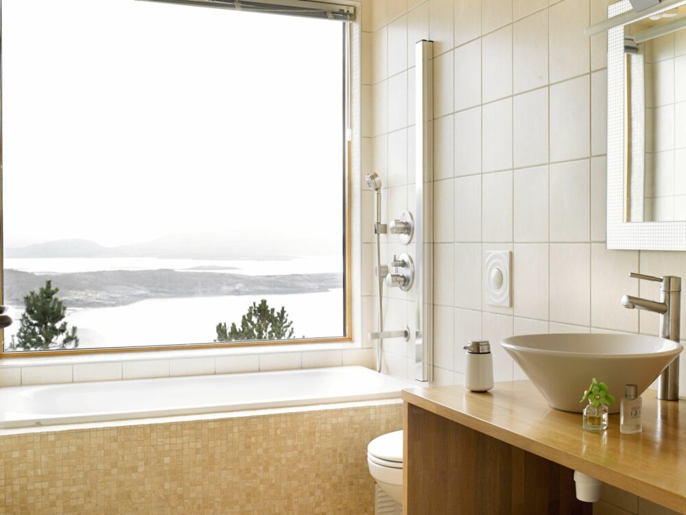 BAD MED UTSYN: Til og med fra badekaret kan man nyte den fantastiske utsikten mot Linesøya. Dusjarmatur og håndvask fra
Hans Grohe. Badekaret er murt inn og flislagt med mosaikk av travertin.