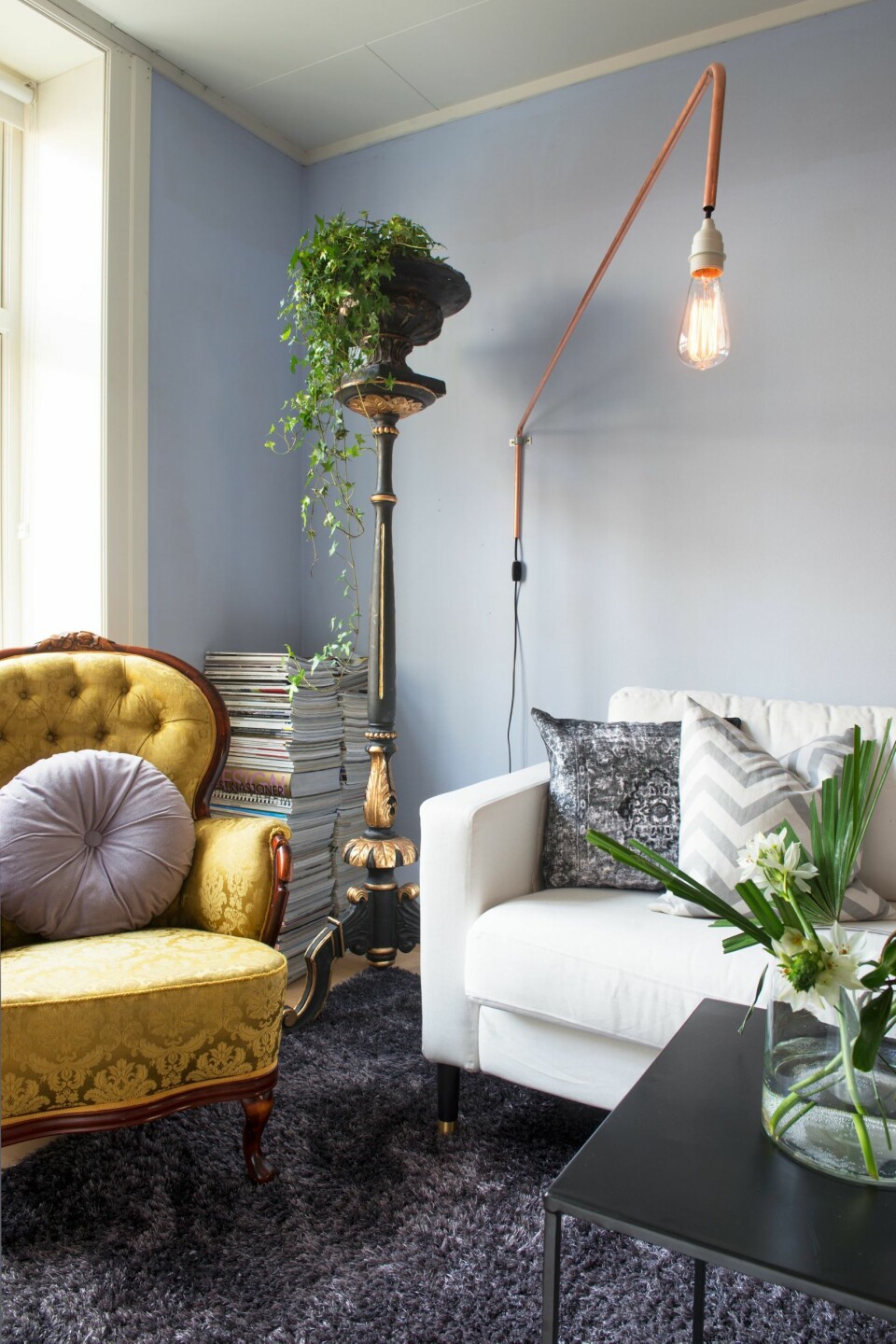 Små grep. Lenestolen og blomsterstolen var blant de første møblene Ida kjøpte brukt og på auksjon da hun som
16-åring begynte å samle på møbler. Lampen har hun laget
selv. Sofaen er fra Ikea, med nye ben fra Prettypegs.se.
Blåfargen på veggen heter NCS S 0515-R80B.