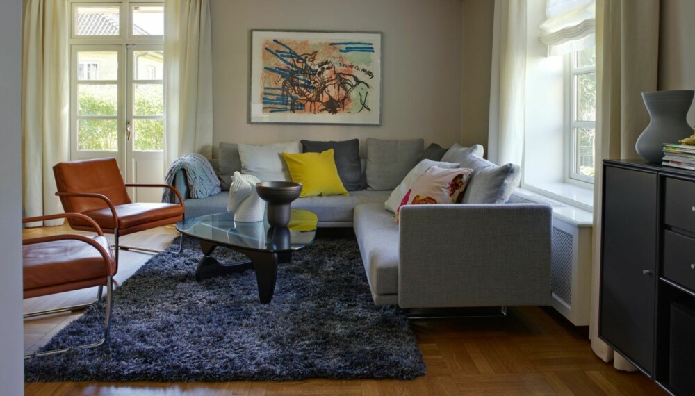 GODT FOR ØYET: Grått er gjennomgående i hele huset. Hovedfargen i stuen er Jotun 10182 Hvit Lin, fargekode NCS 1902-Y42R. Kunst av Bjarne Melgaard. Hjørnesofaen Prime Time og lenestolen George Lounge er fra Knoll, og teppet er fra Kymo. Alt er kjøpt hos Tannum Møbler. Pledd fra Palma, gul pute fra Expo Nova og hesteskulptur fra Jonathan Adler. GODT FOR ØYET: Grått er gjennomgående i hele huset. Hovedfargen i stuen er Jotun 10182 Hvit Lin, fargekode NCS 1902-Y42R. Kunst av Bjarne Melgaard. Hjørnesofaen Prime Time og lenestolen George Lounge er fra Knoll, og teppet er fra Kymo. Alt er kjøpt hos Tannum Møbler. Pledd fra Palma, gul pute fra Expo Nova og hesteskulptur fra Jonathan Adler.