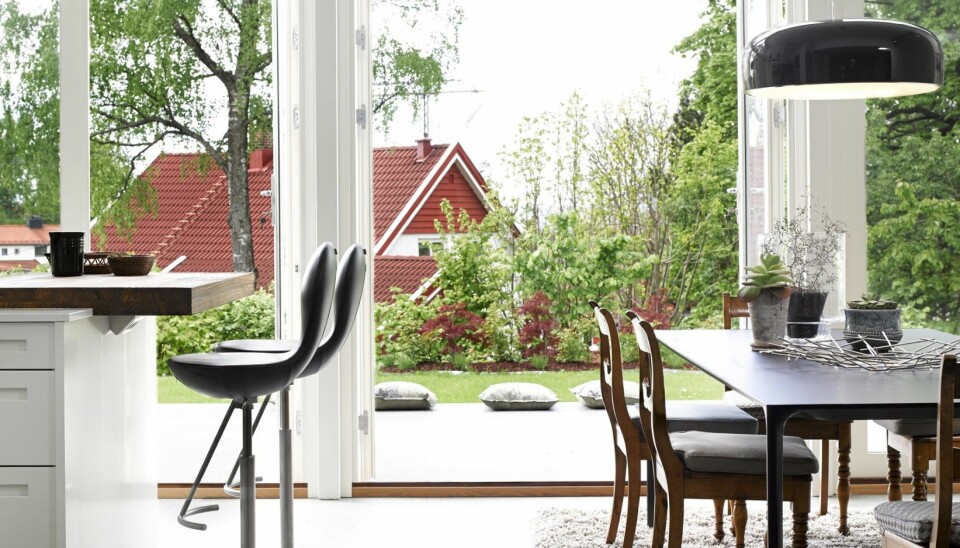 NÆRKONTAKT: Deler av uteplassen er innlemmet i det flunkende nye kjøkkenet. De store vinduene i huset sørger for at hagen nærmest oppleves som en del av boligen. Betonggulvet er trukket ut i hagen. Det skaper en god flyt og er deilig å gå barbent på. Nuur
spisebord er fra Arper, og barstolene er fra Varier.