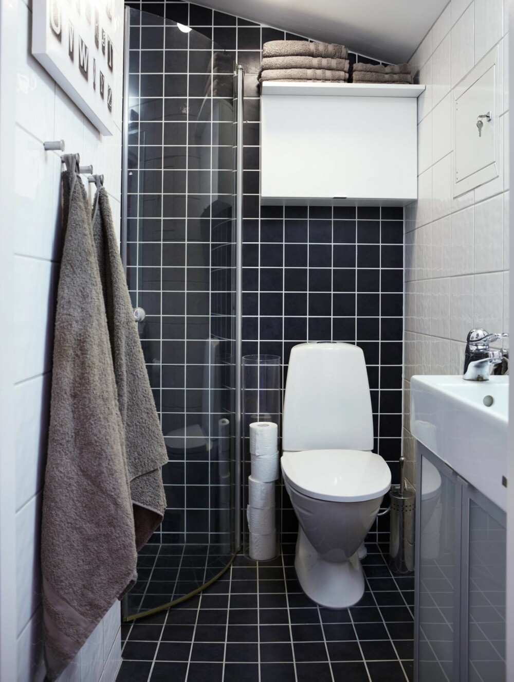 BRUK FARGE PÅ BAD: Den usedvanlig smale vasken, 20 x 70 cm, ble et funn for dette lille badet, den er fra Ikea. Ved dusjen er det montert en halvpart av et 90 cm dusjhjørne. Veggen er svingbar og kan dyttes helt
inn mot veggen når dusjen ikke er i bruk. Nye, svarte fliser gir inntrykk av dybde i rommet. BRUK FARGE PÅ BAD: Den usedvanlig smale vasken, 20 x 70 cm, ble et funn for dette lille badet, den er fra Ikea. Ved dusjen er det montert en halvpart av et 90 cm dusjhjørne. Veggen er svingbar og kan dyttes helt
inn mot veggen når dusjen ikke er i bruk. Nye, svarte fliser gir inntrykk av dybde i rommet.