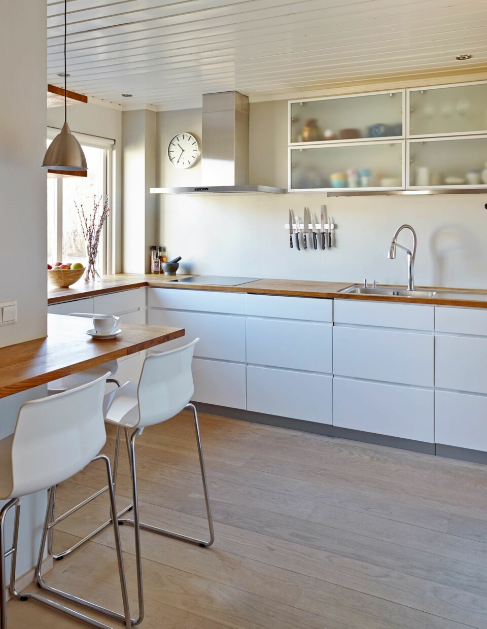 FRIGJORDE PLASS: I og med at det ble montert skapvegg, kan familien bruke færre overskap, og kjøkkenet virker større. Veggen over vask og komfyr er malt med Lady Easy Clean som er en vaskbar veggmaling. Resten av veggen er malt med Lady S2502-Y, tak 0502-Y. Dype kjøkkenskuffer inneholder redskaper som barna selv kan hente. Viften er fra Thermex, Decor 820. Barkrakker ved arbeids- og frokostplassen er fra Ikea.