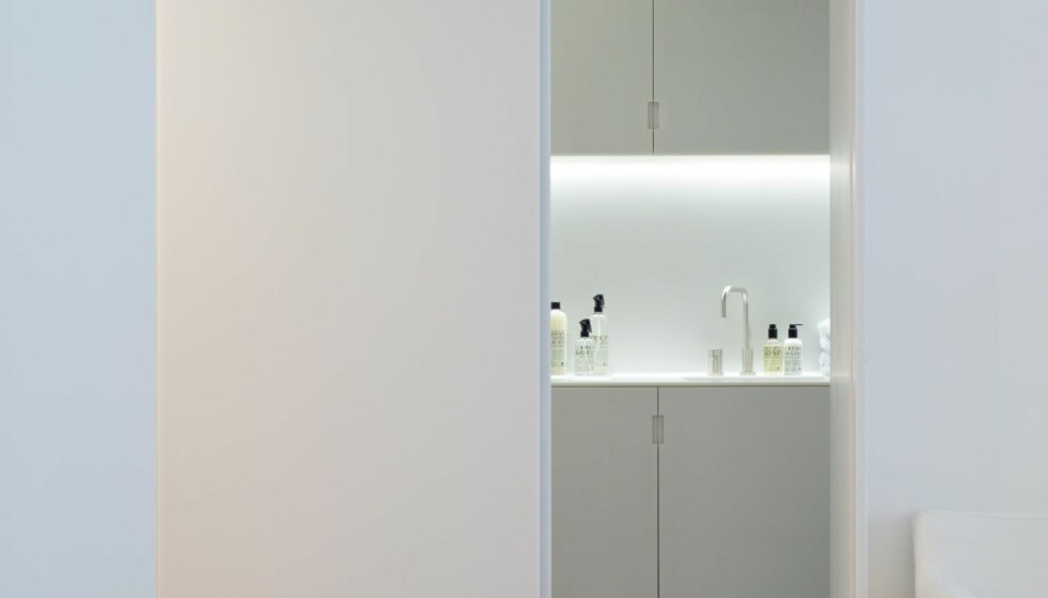 MINIMALISTISK: Vaskerommet du ser gløtt av her er mer påkostet enn man skulle tro ved første øyekast. Her er nemlig både vegger og gulv, skapfronter og vask laget i komposittmaterialet Corian. Prosjektet er ved arkitekt Henrik Nømm, a-tract.no.