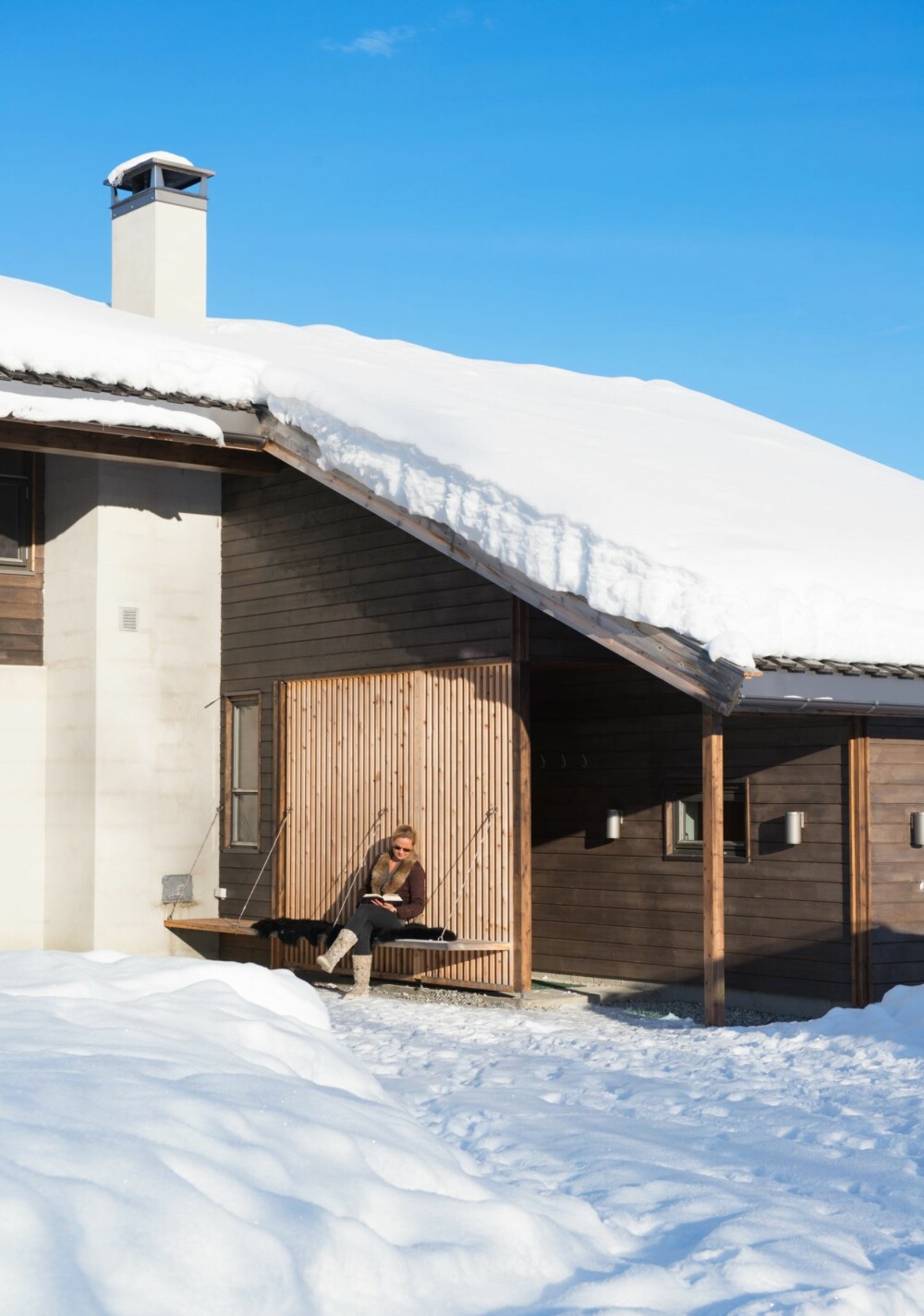 NYTER LIVET: Den beste uteplassen er der sola kommer rundt tidlig på ettermiddagen. Selve inngangen til hytta går gjennom et vindfang på baksiden av spileveggen.