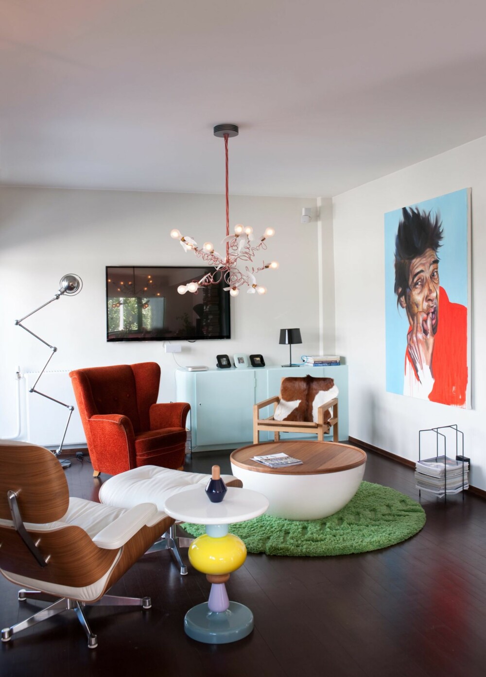SOFALØS STUE: Stuen er innredet med en uvanlig møbelmiks:
Eames Lounge Chair fra Vitra, Shuffle sidebord fra Andtradition,
bord med oppbevaringsplass fra Bolia, en gammel ørelappstol
og en enkel hvilestol fra R.O.O.M. kledd med kuskinn fra Ikea.
Gulvteppet er fra Permafrost, taklampen fra Ingo Maurer. Bildet er
malt av Kristoffer Evang. Flatskjermen er nesten borte i vrimmelen. SOFALØS STUE: Stuen er innredet med en uvanlig møbelmiks:
Eames Lounge Chair fra Vitra, Shuffle sidebord fra Andtradition,
bord med oppbevaringsplass fra Bolia, en gammel ørelappstol
og en enkel hvilestol fra R.O.O.M. kledd med kuskinn fra Ikea.
Gulvteppet er fra Permafrost, taklampen fra Ingo Maurer. Bildet er
malt av Kristoffer Evang. Flatskjermen er nesten borte i vrimmelen.