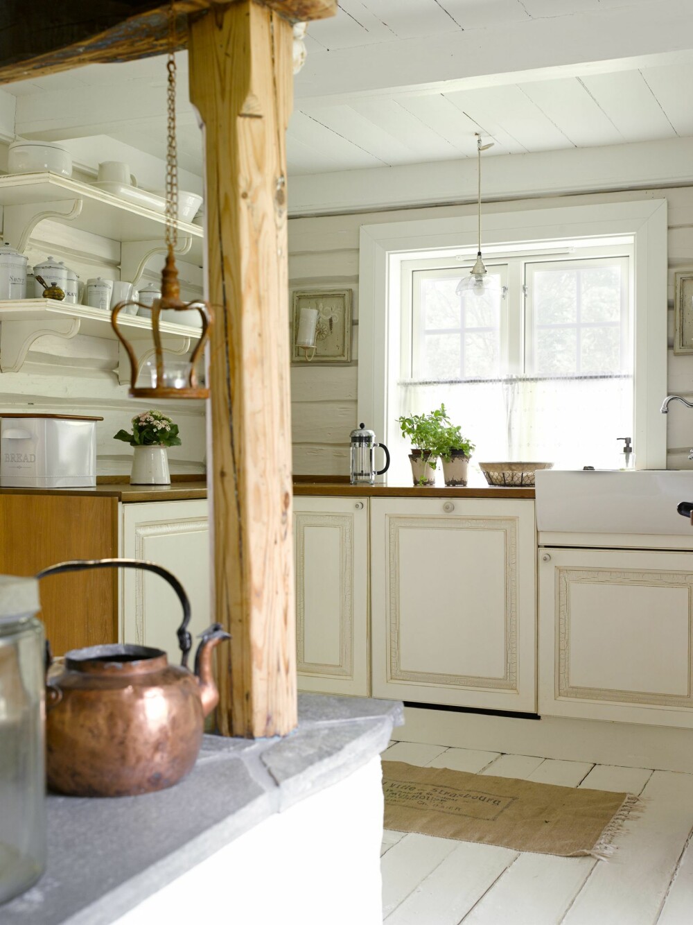 LYST: Dagslyset reflekteres rundt i det lille, hvitmalte kjøkkenet. Innredningen er laget etter mål. 
