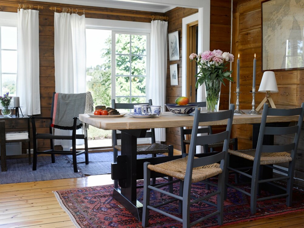 SPISEPLASS: I enden av stuen står et spisebord fra Helene og Espen snekkerverksted, med gamle jærstoler. Her samles hytteeierne til hyggelige middager med venner og familie.
