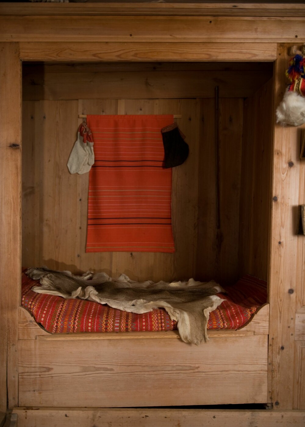 SENG MED SKAP: Den gamle skapsengen med vevd teppe og rådyrskinn står fortsatt der i «Utistuggu». I enden av sengen er det skap med plass til porselen og annet som fulgte med hytta. 
