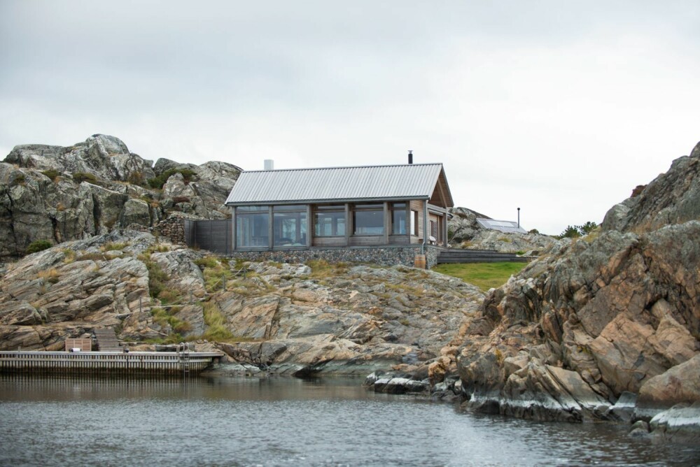 KORTSIDEN: Slik ser hytta ut når man ankommer brygga. Den korte delen ligger vendt mot sjøen. Med lerk i kledningen og stein som forsterkende elementer har arkitekten lykkes med å legge hytta inn i landskapet.