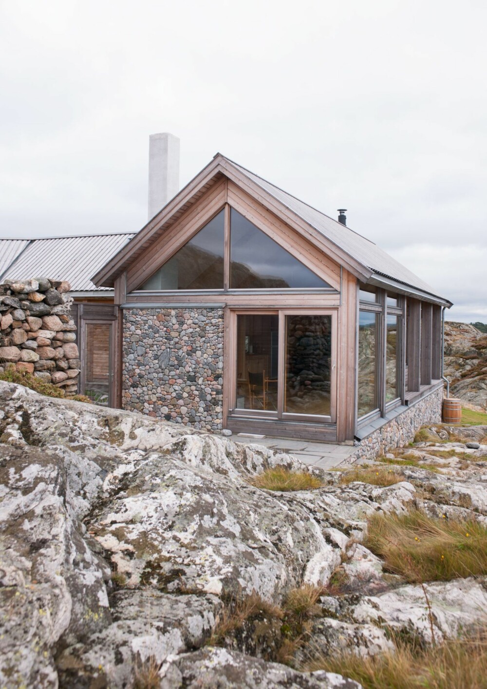 STEIN PÅ VEGGEN: Deler av ytterveggen mot vest er belagt med rullesteiner. I tillegg til å beskytte huset mot vær 
og vind er det et dekorativt innslag som er en slags fortsettelse av landskapet omkring hytta.