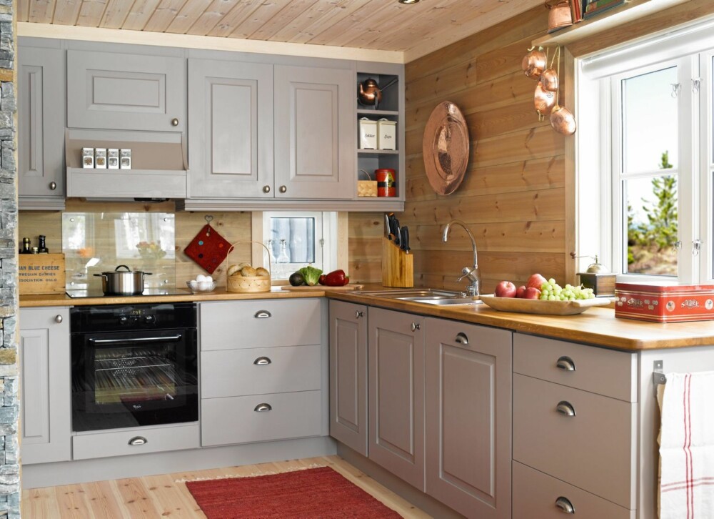 GRÅ HARMONI: Det nye kjøkkenet har fått en fargepalett i grått og beige med røde innslag. Den lange kjøkkenbenken gir god plass til matlaging.