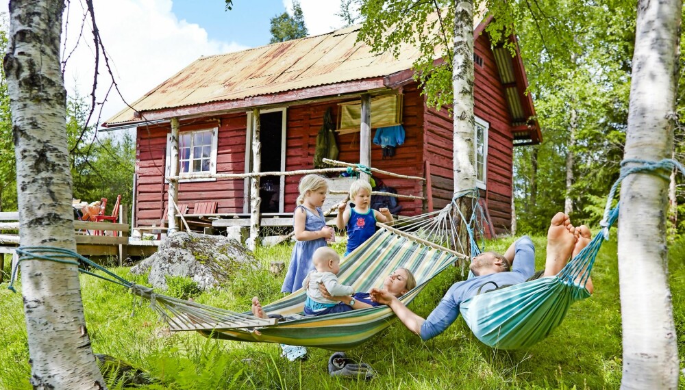 HENGER SAMMEN I SKOGEN: Hytteeierne Ingunn (30) og Gunnar (32) har en rolig stund i hengekøya sammen med minstemann Joel (på fanget), Naomi (5) og Boas (4). (FOTO: Sveinung Bråthen) 