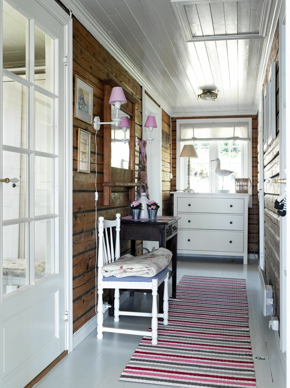 TØMMERET BEVART: I gangen er de originale tømmerveggene fra stabburet hentet frem. Lyse farger ellers fremhever veggene og gjør rommet lyst og trivelig.