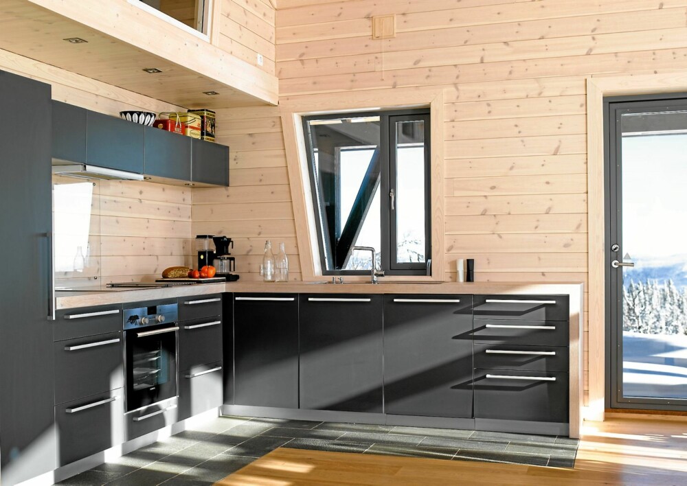 TILPASSET KJØKKEN: Kjøkkenløsningen på hytta er fra Kvik, mens den hvitoljede kjøkkenbenken i eik er laget på stedet av en møbelsnekker.