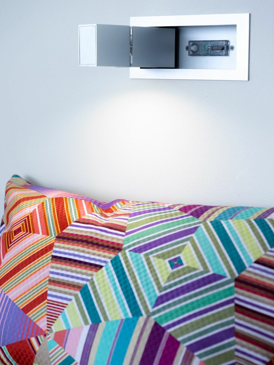 SNERTEN LØSNING: Leselampen fra ISØ Elektrikk er innebygget i veggen, fri for synlige ledninger. En smart løsning hvis en vil sove når den andre leser. Montert av Fagelektriker i Bergen. Pute fra Hjem, kjære hjem.