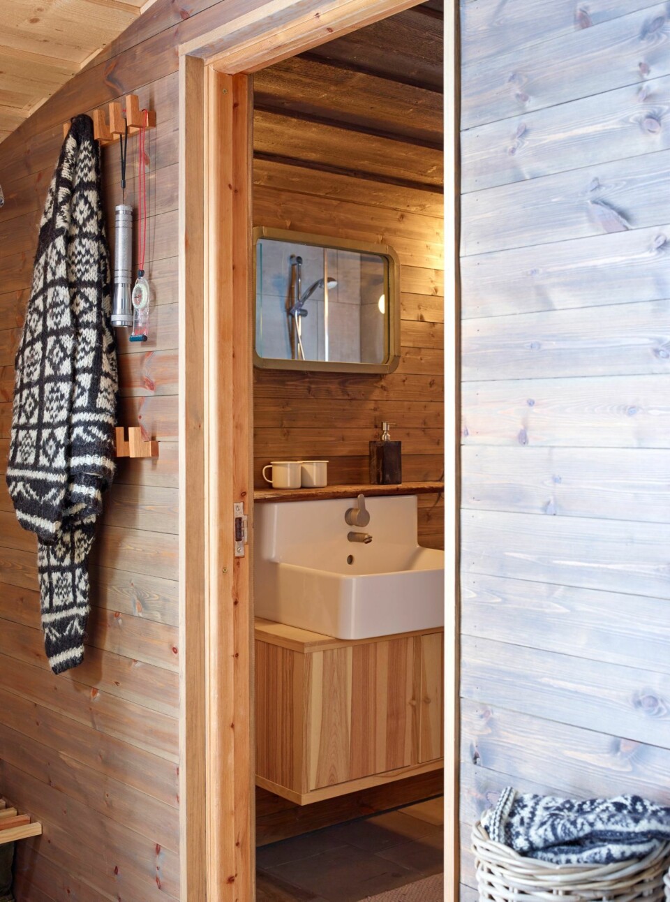 Innlemmet: Den gamle utedoen og en bod er forvandlet til et praktisk bad og en gang. Det er gjennomgående bruk av naturlige materialer som tåler slitasje og røff hyttebruk. Gammelt treverk er brukt på nytt.
Naturstein på badet, lintekstiler og sink.
