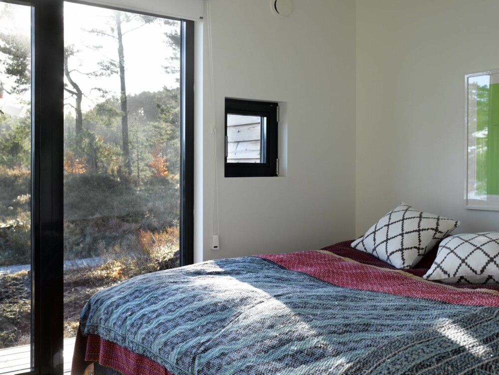Naturlig våken: Tenk å våkne opp til solskinnet som siles gjennom trekronene og fuglekvitteret utenfor. De store skyvedørene i glass inviterer naturen inn på soverommet.