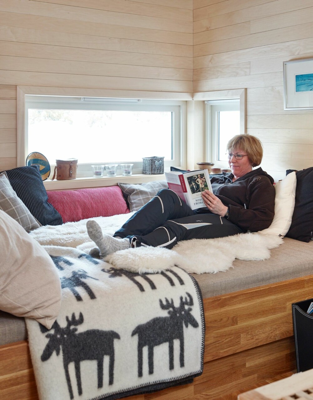 Koseplassen: Hytteeier Trine Sjøblom er glad i å lese bøker. Dagsengen kan også benyttes som soveplass dersom hele storfamilien skulle komme på besøk.