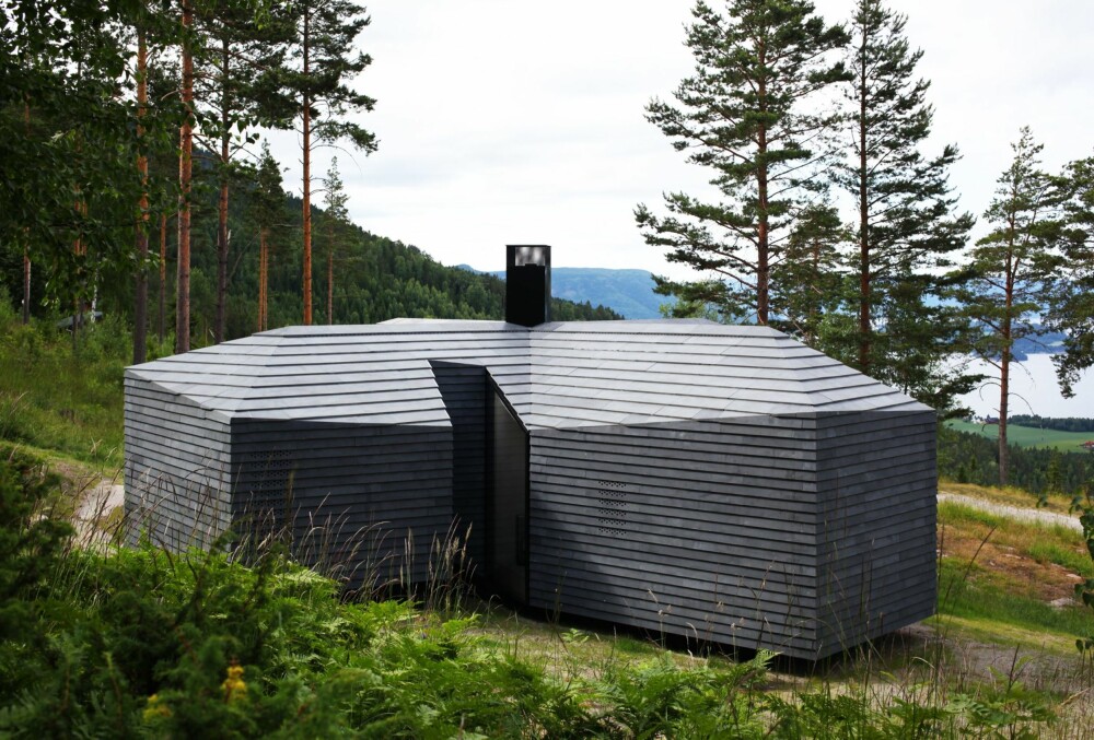 Solcelle rundt skorsteinen: Hytta er uten innlagt vann og strøm. Solcellepaneler er integrert i beslaget rundt skorsteinen. Konstruksjonen er prefabrikkert limtre. Hytta er fundamentert med stålbolter boret ned i fjellet. Foto: Atelier Oslo Solcelle rundt skorsteinen: Hytta er uten innlagt vann og strøm. Solcellepaneler er integrert i beslaget rundt skorsteinen. Konstruksjonen er prefabrikkert limtre. Hytta er fundamentert med stålbolter boret ned i fjellet. Foto: Atelier Oslo