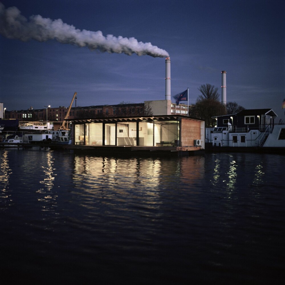 STORE GLASSFLATER: Den moderne husbåten lyser opp i nattemørket.