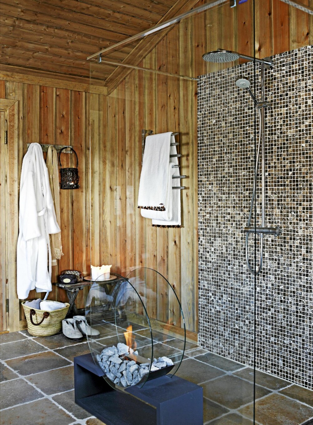 SPAOPPLEVELSE. I dusjen er det et felt med mosaikkfliser. Biopeisen er dekorativ samtidig som den gir varme. På gulvet er det lagt kalksteinsfliser.