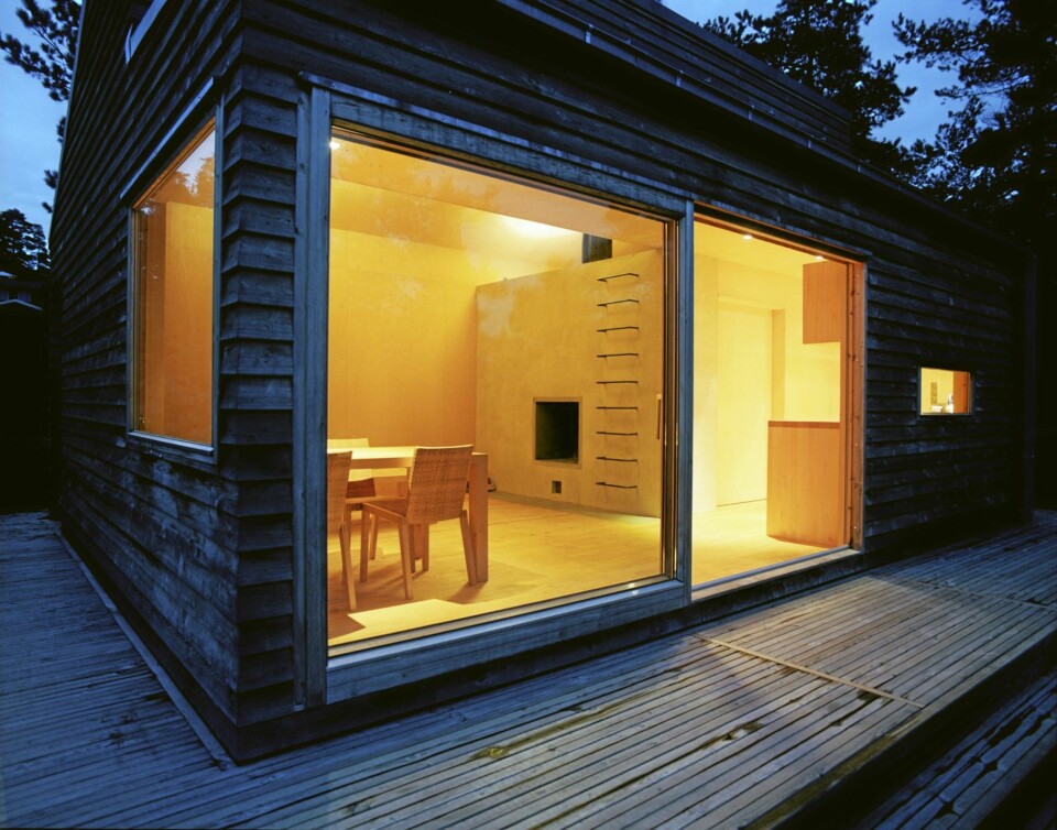 FUNKSJONELT ALLROM: Bak store glassvinduer er allrommet, med peis og trapp opp til hemsen.