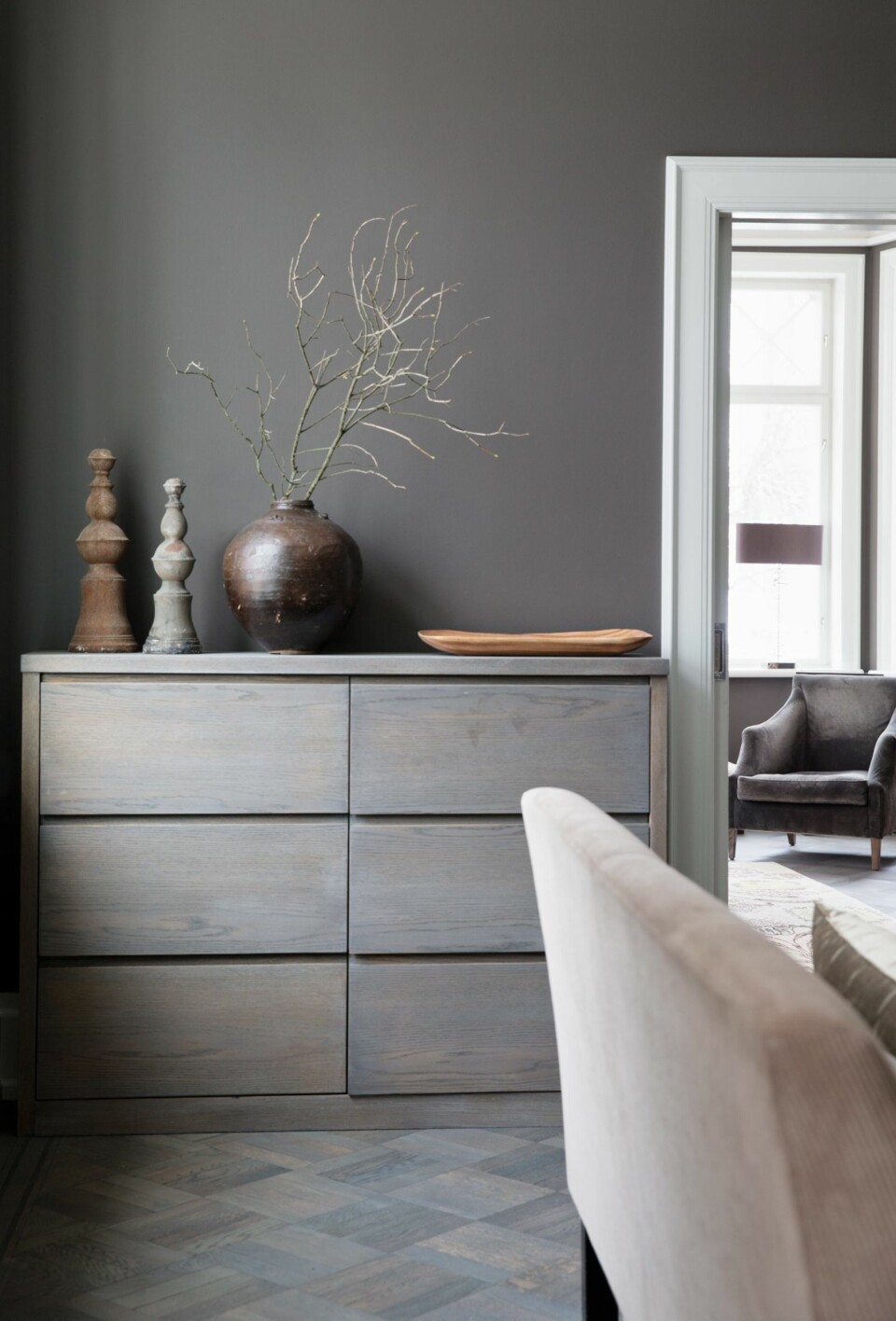 SOBER PALETT: Kjøkkenet er gjennomført innredet i gråtoner. Eikegulvet fra Parkettgruppen er innfarget lik den øvrige kjøkkeninnredningen. Det er montert skyvedører inn til stuen, som ligger vegg i vegg. Styling: Tone Kroken.