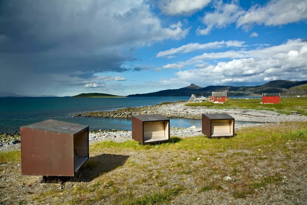 Værbeskyttende sittebokser på rasteplasssen ved riksveg 889 i Snefjord, Nasjonal Turistveg Havøysund. Arkitekt: PUSHAK arkitekter (Langeland, Drage Kleiva, Melbye, Gromholt).