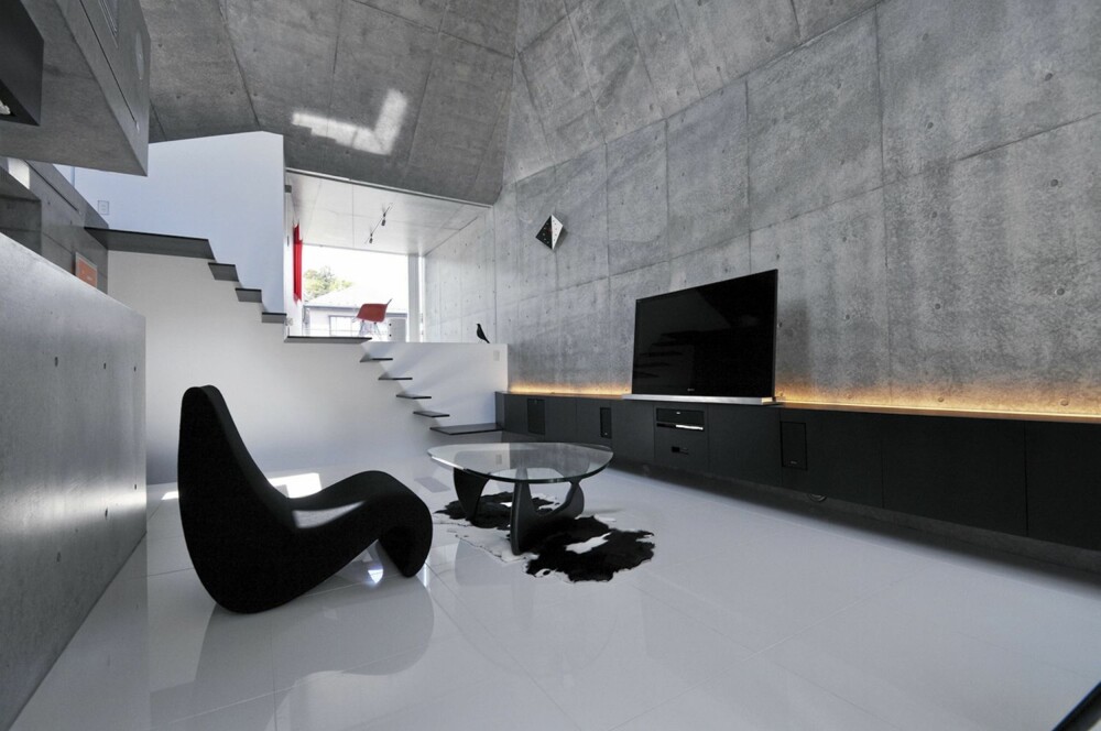 STUE: Stuen er spartansk med få møbler og inakne vegger. Bak TV-benken er det satt inn belysning.