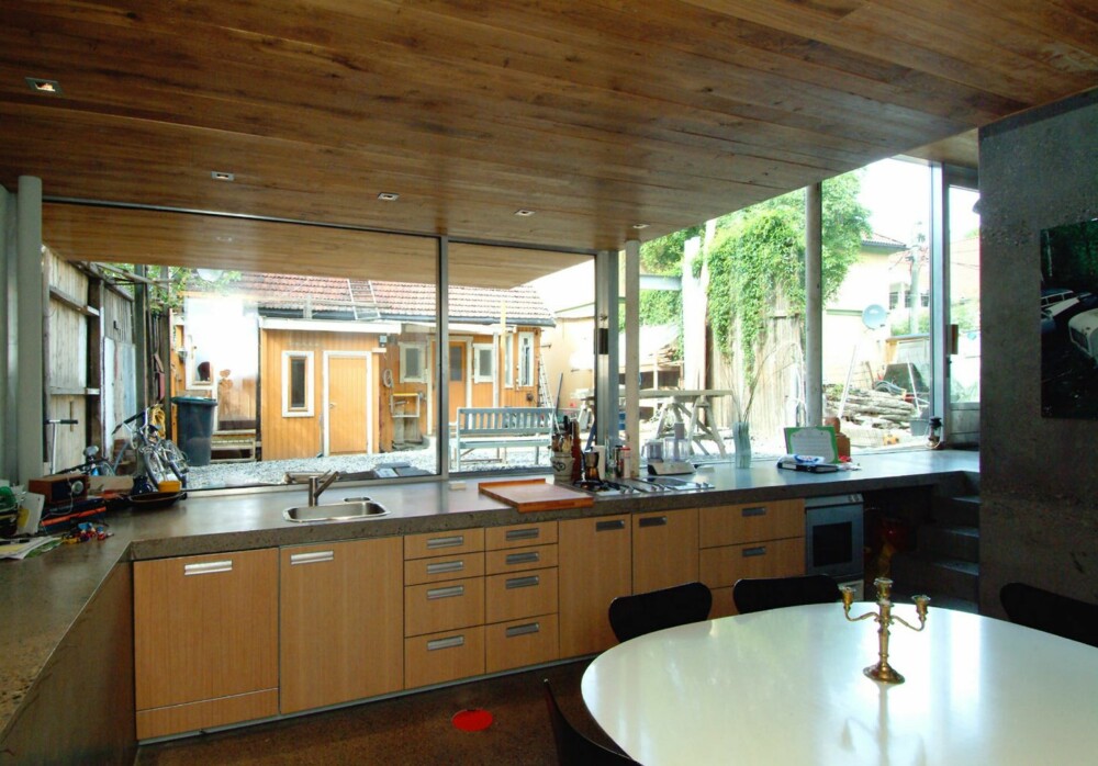 ÅPENT KJØKKEN: Den åpne kjøkkenløsningen fremheves med den utstrakte glassbruken. Både på gulvet og på kjøkkenbenken er det brukt slipt betong.
