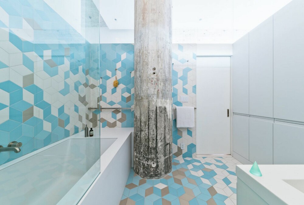 FLYTER: På badet er det lagt fliser i tre farger og ni nyanser i et 3D-mønster, og uten at det er markert skiller mellom gulv og vegg. Sammen med den markante betongsøylen gir det rommet en helt spesiell karakter.