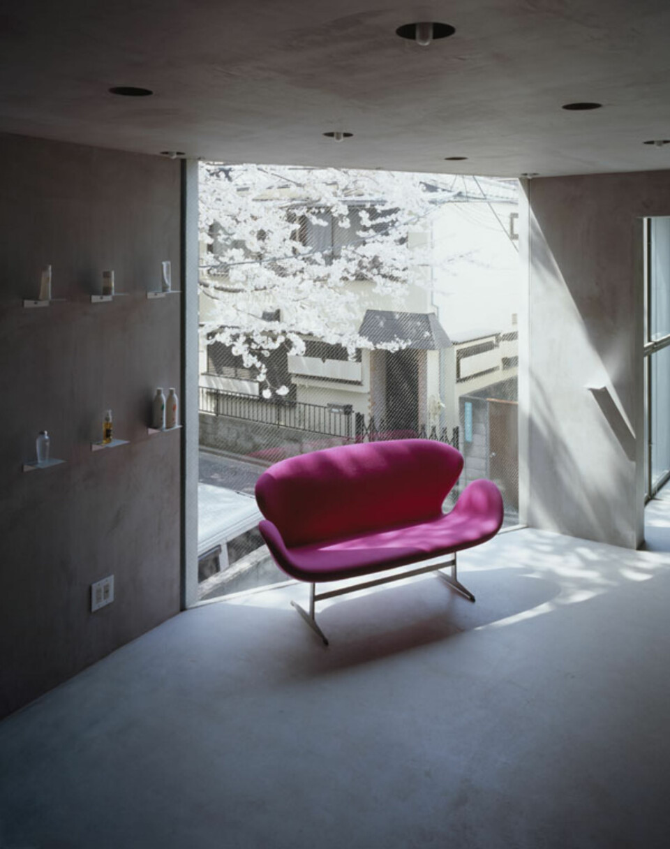 FARGEKLATT: En knall rosa sofa fungerer som en fargeklatt i det ellers nakne interiøret.