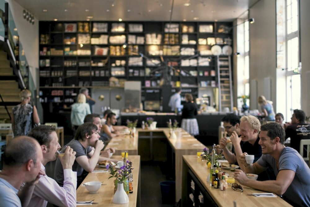 LANGE FROKOSTER I HOLLAND: Mingling over langbord i den store restauranten med himmelhøyt under taket.