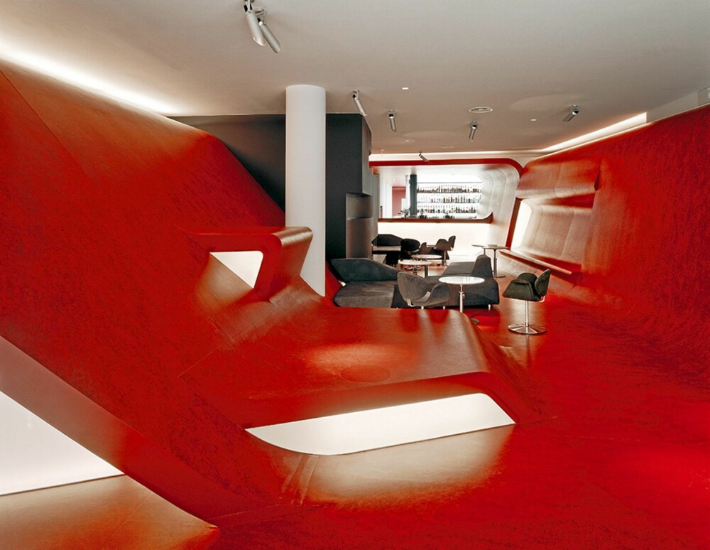 SPENNENDE INTERIØR: Hotellets røde lobby og lounge har få rette vinkler. Interiører gir inntrykk av en omfavnelse fordi veggene går i ett med gulvet.