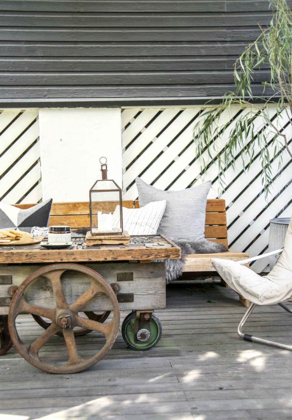 KREATIVT: Det flotte bordet er en eldre togvogn med en håndlaget plate laget av gamle trykkbokstaver. Tekstiler, puter og skinn fra Bolina. Styling: Kirsten Visdal.