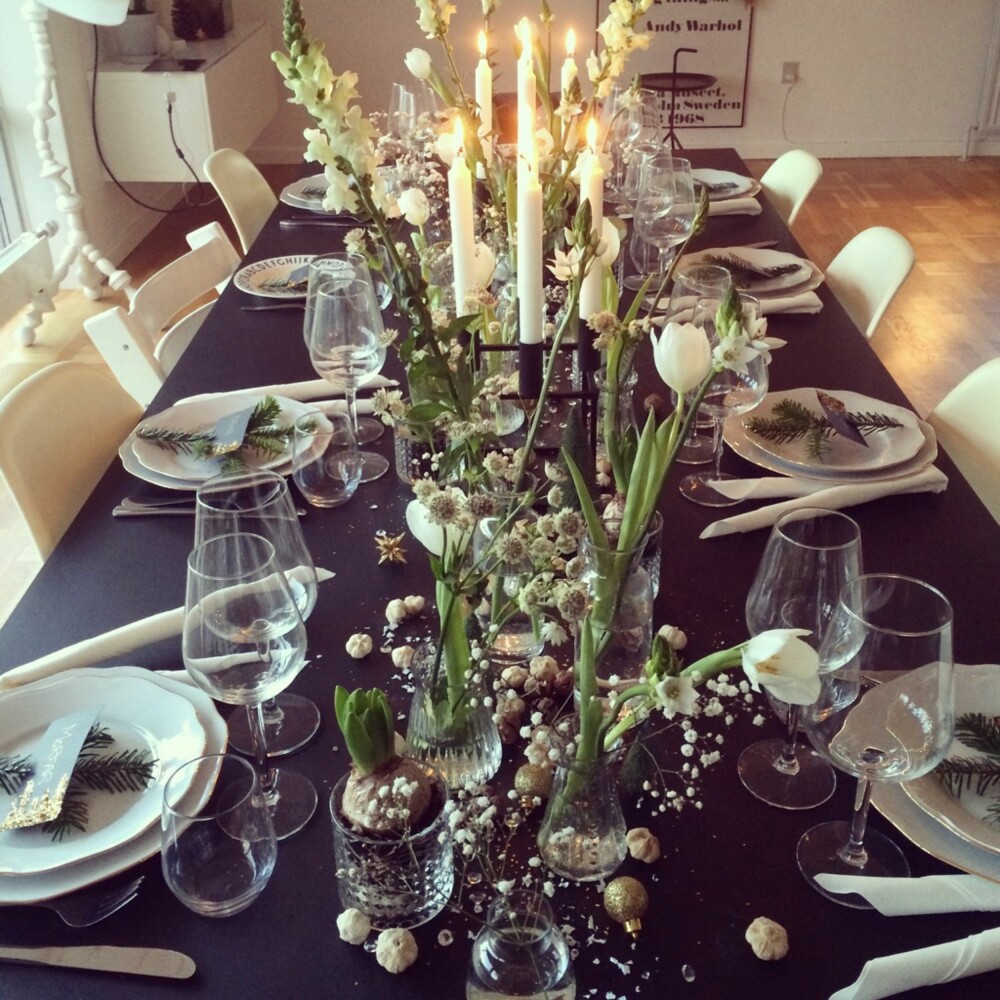 SORT OG HVITT: Instagrammer Camilla Hamiltorn dekket fjorårets julebord med svart duk og hvite blomster. På bordet har hun strødd kongler, hvitløk og glitter. Tallerkenene er pyntet med granbar og hjemmelagede bordkort.