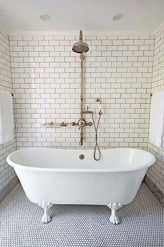 NOSTALGISK: Husets to bad er utstyrt med hvite metrofliser og sorte fuger på veggene, mens gulvet har sekskantede ”penny tiles”. Dette badet ligger i tilknytning til hovedsoverommet og har frittstående badekar med løveføtter. Alle armaturer er i nostalgisk stil.