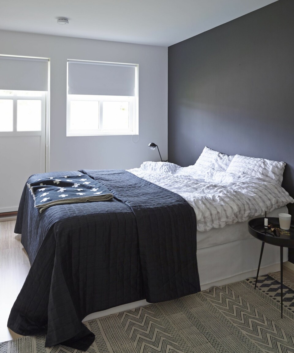 SVART SOM NATTEN: En vegg er malt i Jotun Lady 9938 Dempet Sort, og skaper slik en lun atmosfære på foreldresoverommet. Sengetøy i krepp fra Kid, sengeteppe fra Bohus og pledd fra Pia Wallén. Teppe fra House Doctor og nattbord fra Modena.