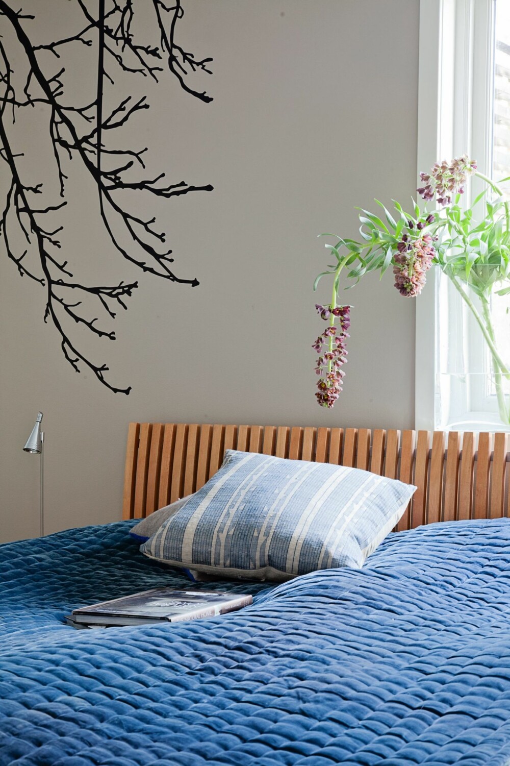 GOD NATT: Soverommet er holdt i en 
nøytral og delikat beige-grå farge. Wallstickeren 
på veggen er en fin organisk detalj, og gjør seg sammen 
med de delikate blå tekstilene i sengen.